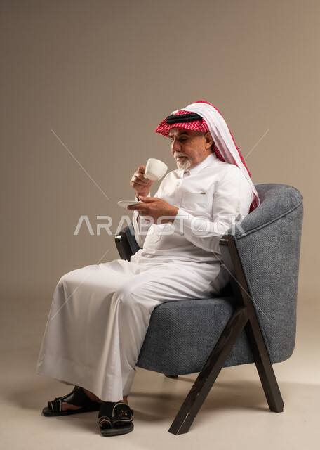 رجل سعودي مسن يشرب القهوة في الاستوديو