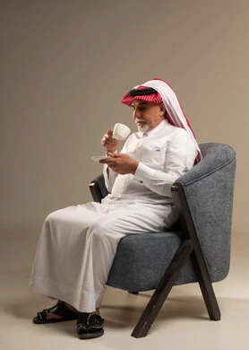 Senior Saudi Man Drinking Coffee in Armchair