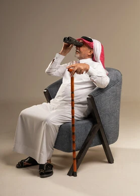 رجل سعودي مسن مع منظار وعصا مشي