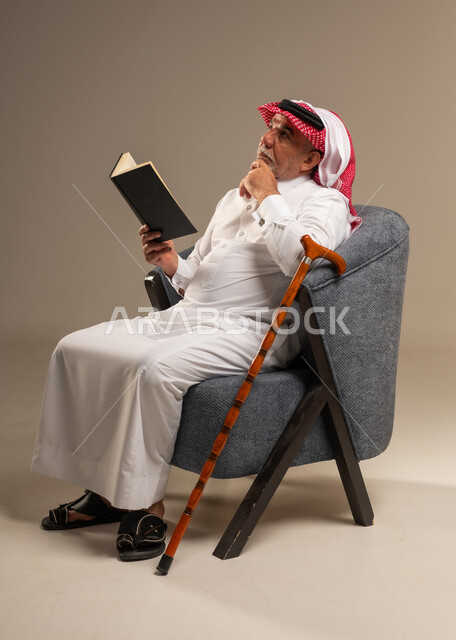 Elderly Saudi Man Thinking While Reading a Book