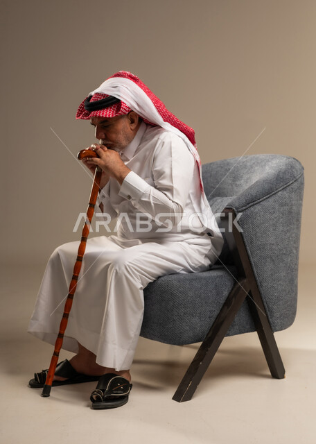 رجل سعودي مسن بوضعية تفكير بالزي التقليدي