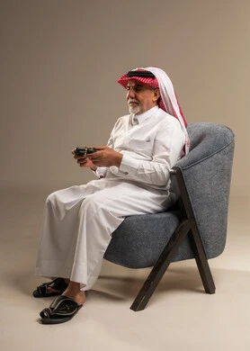 Elderly Saudi Man Holding Game Controller in Studio