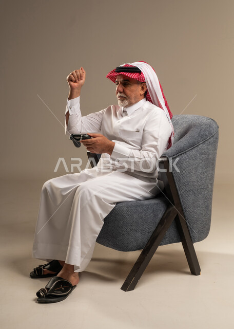 Elderly Saudi Man Holding Game Controller in Studio