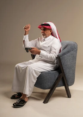 Elderly Saudi Man Holding Game Controller in Studio