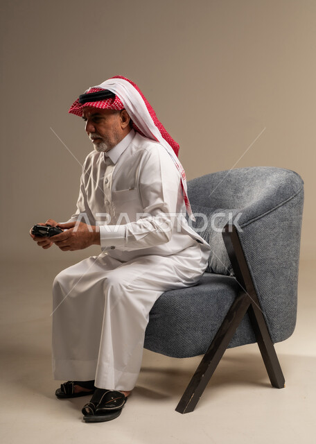 رجل سعودي مسن يلعب ألعاب الفيديو في استوديو