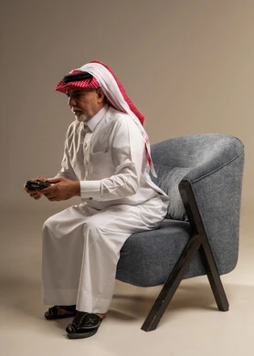 رجل سعودي مسن يلعب ألعاب الفيديو في استوديو