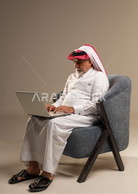 رجل سعودي مسن يستخدم المحمول في الاستوديو