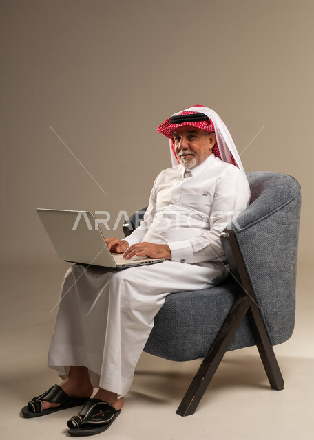 رجل سعودي مسن يستخدم المحمول في استوديو