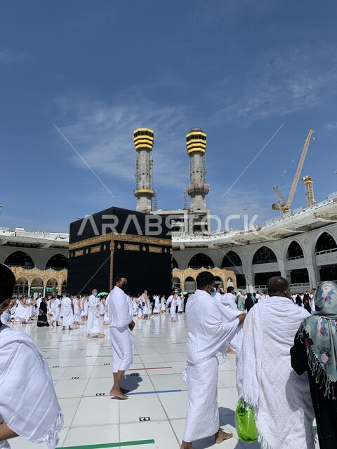 صورة للحرم المكي في المملكة العربية السعودية ، مجموعة من الحجاج والمعتمرين يرتدون الكمامة متبعين اجراءات الوقاية و السلامة من فايروس كورونا يؤدون مناسك الحج في مكة المكرمة ، جمال الحرم المكي الشريف ، معالم دينية مشهورة بالسعودية 