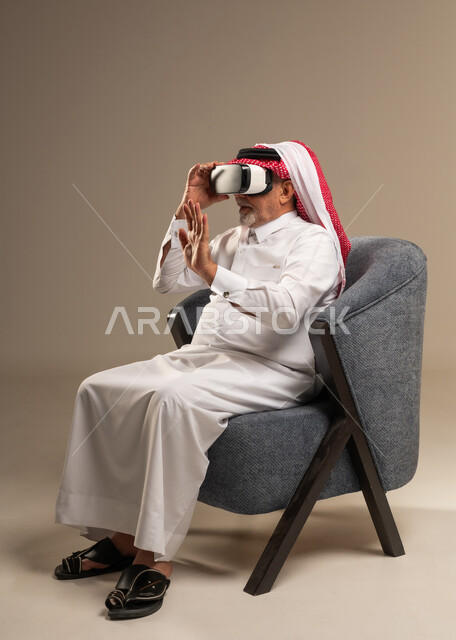 Elderly Saudi Man Using VR Headset in Armchair