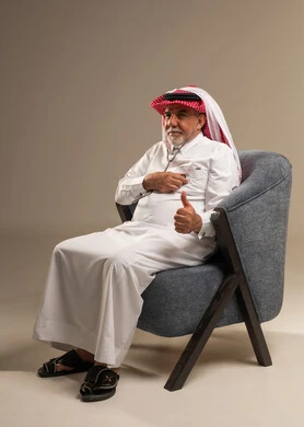 رجل سعودي مسن مع سماعة طبية يرفع إبهامه