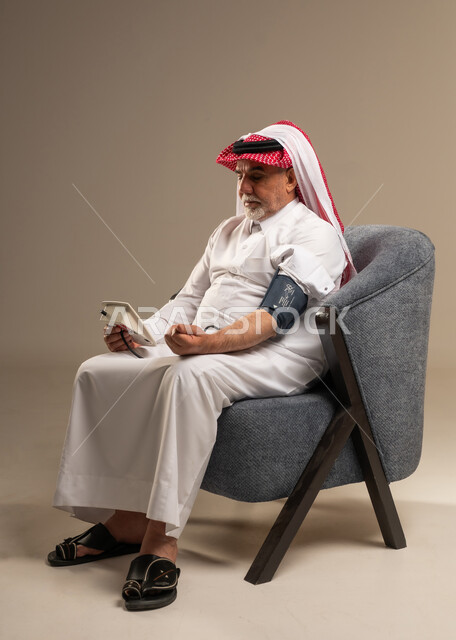 رجل سعودي مسن يقيس ضغط الدم في المنزل