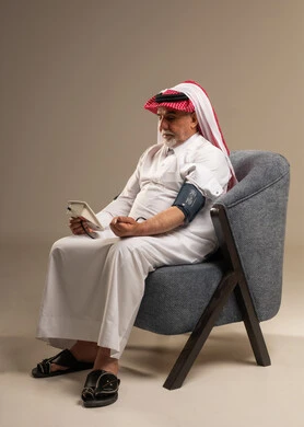 رجل سعودي مسن يقيس ضغط الدم في المنزل