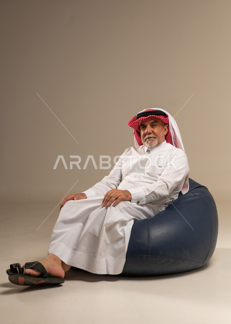 Senior Saudi Man Sitting on Beanbag in Studio