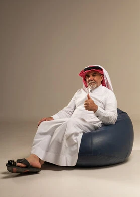 Senior Saudi Man on Beanbag Giving Thumbs Up