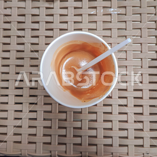 صورة مقربة من أعلى لكوب قهوة على سطح بلاستيكي في أحد الكافيهات ، قهوة اسبريسو ، نسكافيه ، كابيتشينو ، مشروبات ساخنة