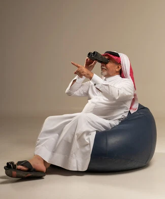 Saudi Senior Man in Thobe Using Binoculars in Studio