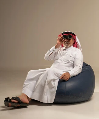 Saudi Senior Man with Binoculars Sitting on Bean Bag