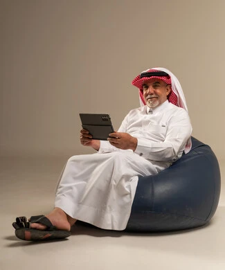 رجل سعودي مسن مع جهاز لوحي على بين باج