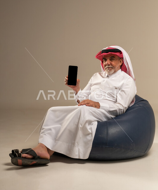 Senior Saudi Man with Smartphone on Bean Bag