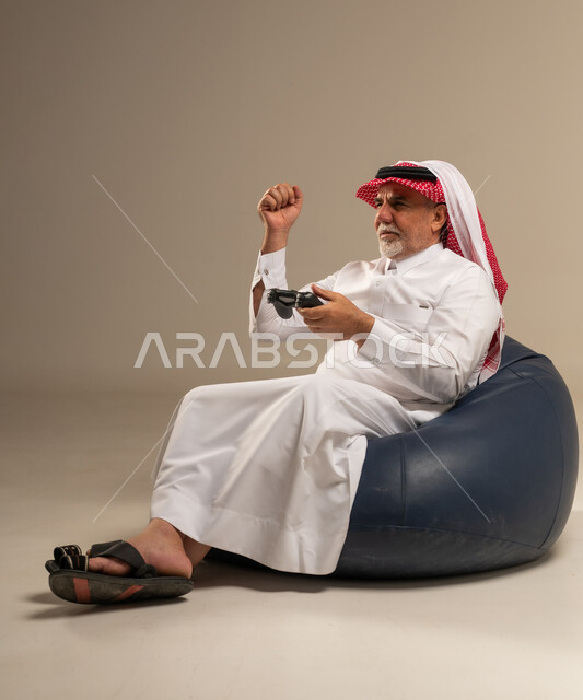 رجل سعودي مسن يلعب ألعاب الفيديو في الاستوديو