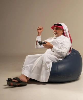 رجل سعودي مسن يلعب ألعاب الفيديو في الاستوديو