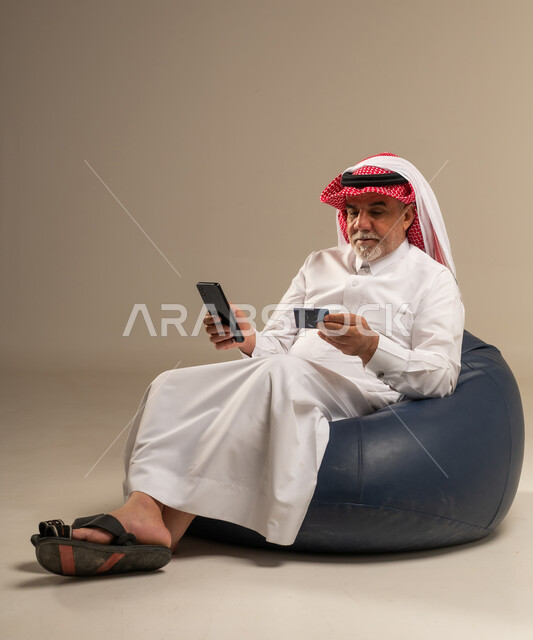 رجل سعودي مسن يستخدم بطاقة ائتمان وهاتف ذكي