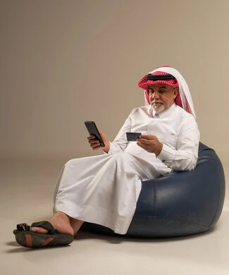 رجل سعودي مسن يستخدم بطاقة ائتمان وهاتف ذكي
