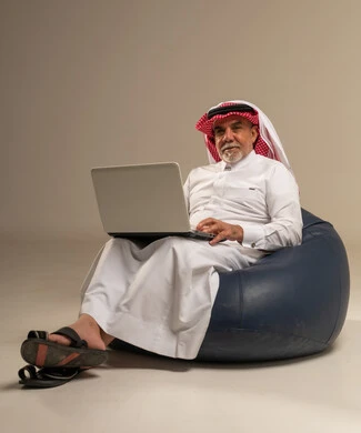 رجل سعودي مسن يستخدم الحاسوب المحمول في الاستوديو