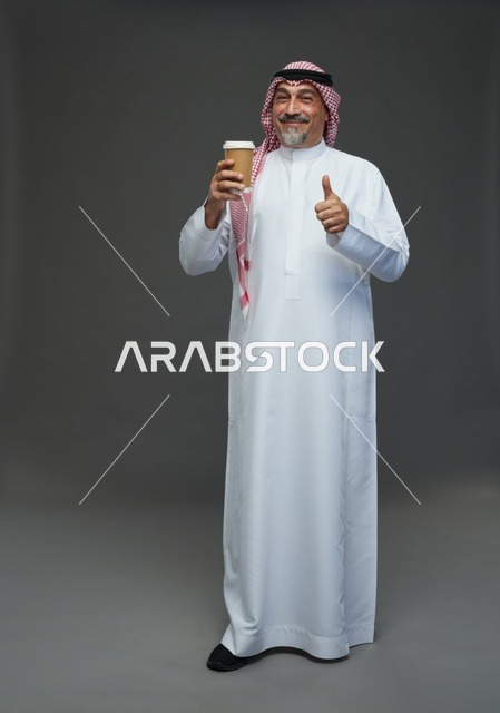 رجل  عربي سعودي خليجي مسن يرتدي الزي الثوب الابيض والشماغ ويحمل فنجان قهوة,  ايماءات واشارات مختلفه , كامل الجسم, خلفيه رماديه