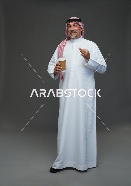 رجل  عربي سعودي خليجي مسن يرتدي الزي الثوب الابيض والشماغ ويحمل فنجان قهوة,  ايماءات واشارات مختلفه , كامل الجسم, خلفيه رماديه