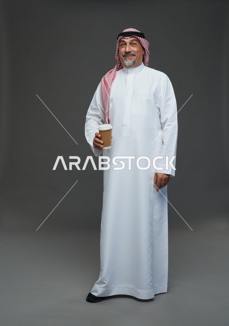 رجل  عربي سعودي خليجي مسن يرتدي الزي الثوب الابيض والشماغ ويحمل فنجان قهوة,  ايماءات واشارات مختلفه , كامل الجسم, خلفيه رماديه