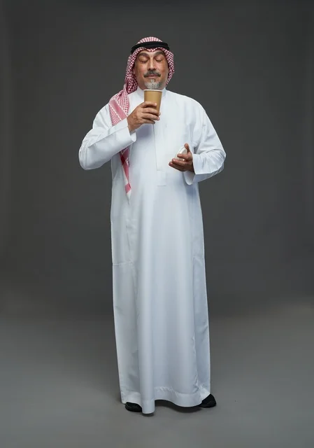 An elderly Arab Saudi Gulf man wearing a white thobe and a shemagh, holding a cup of coffee, with various gestures and signs, full body, gray background.