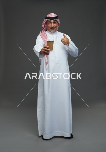 رجل  عربي سعودي خليجي مسن يرتدي الزي الثوب الابيض والشماغ ويحمل فنجان قهوة,  ايماءات واشارات مختلفه , كامل الجسم, خلفيه رماديه
