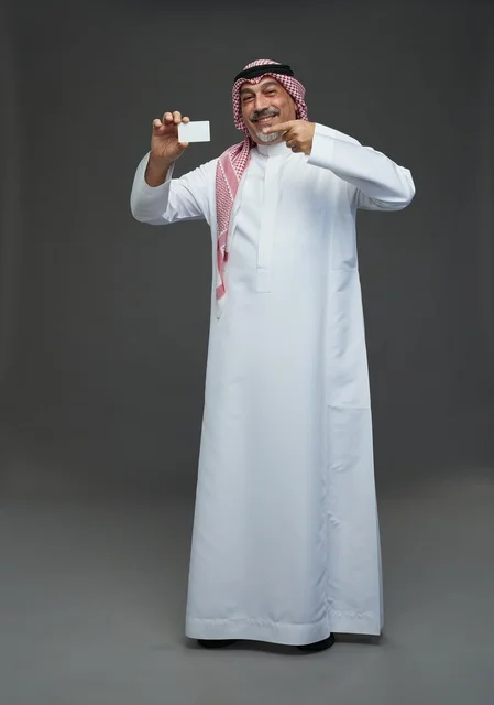 An elderly Arab Saudi Gulf man wearing a white thobe and a shemagh, holding a blank white card, with various gestures and signs, full body, gray background.