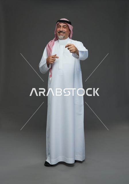 رجل  عربي سعودي خليجي مسن يرتدي الزي الثوب الابيض والشماغ ويمسك بطاقه بيضاء فارغه,  ايماءات واشارات مختلفه , كامل الجسم, خلفيه رماديه