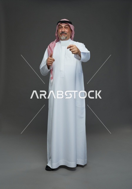 An elderly Arab Saudi Gulf man wearing a white thobe and a shemagh, holding a blank white card, with various gestures and signs, full body, gray background.