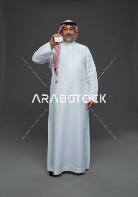 An elderly Arab Saudi Gulf man wearing a white thobe and a shemagh, holding a blank white card, with various gestures and signs, full body, gray background.