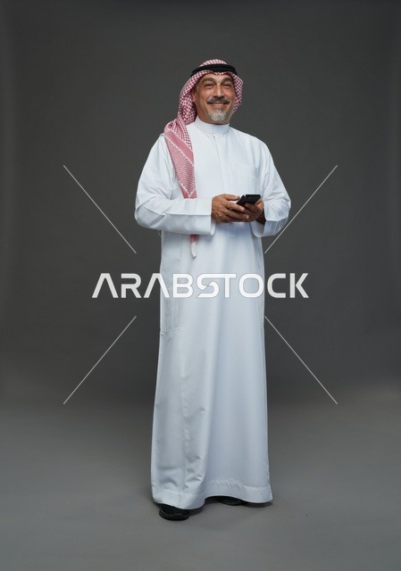 An elderly Arab Saudi Gulf man wearing a white thobe and a shemagh, holding a mobile phone, with various gestures and signals, full body, gray background.