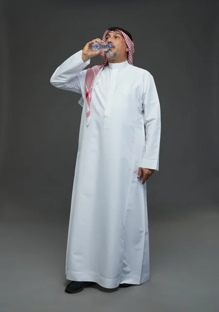 An elderly Arab Saudi Gulf man wearing a white thobe and a shemagh, holding a water bottle, with various gestures and signs, full body, gray background.