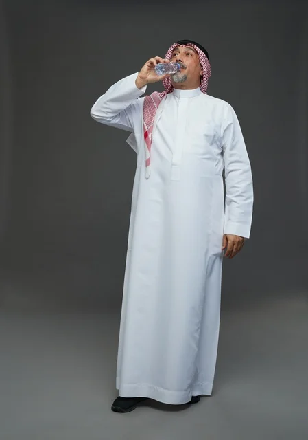 An elderly Arab Saudi Gulf man wearing a white thobe and a shemagh, holding a water bottle, with various gestures and signs, full body, gray background.