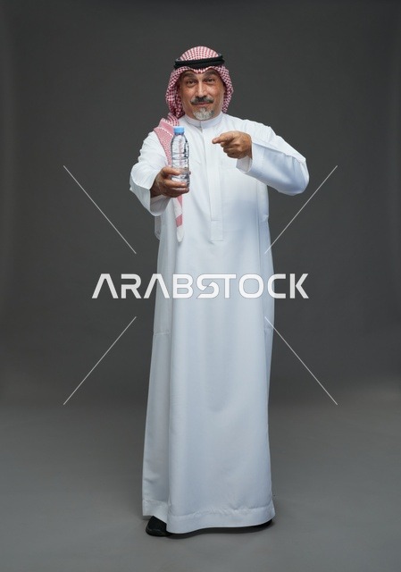 رجل  عربي سعودي خليجي مسن يرتدي الزي الثوب الابيض والشماغ ويحمل قارورة ماء,  ايماءات واشارات مختلفه , كامل الجسم, خلفيه رماديه