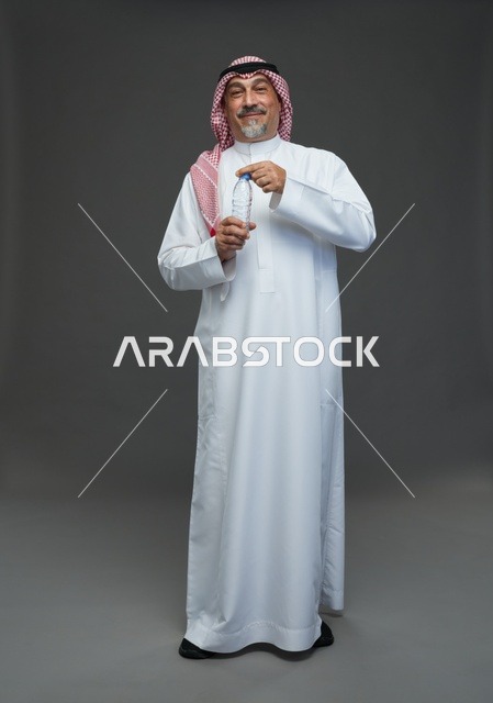 An elderly Arab Saudi Gulf man wearing a white thobe and a shemagh, holding a water bottle, with various gestures and signs, full body, gray background.