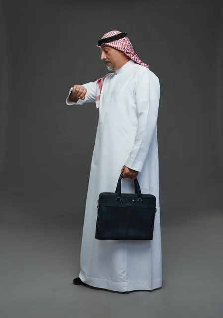 A Saudi Arabian Gulf businessman wearing a white thobe and a shemagh, carrying a laptop bag, with various gestures and signals, full body, gray background.