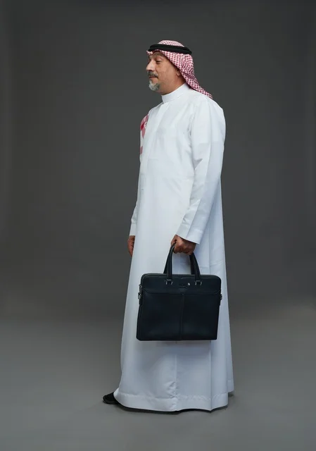 A Saudi Arabian Gulf businessman wearing a white thobe and a shemagh, carrying a laptop bag, with various gestures and signals, full body, gray background.