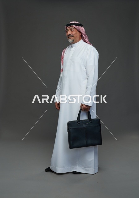 رجل اعمال عربي سعودي خليجي  يرتدي الزي الثوب الابيض والشماغ ويحمل حقيبة اللابتوب,  ايماءات واشارات مختلفه , كامل الجسم, خلفيه رماديه