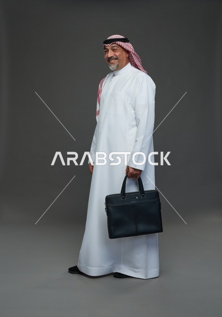 رجل اعمال عربي سعودي خليجي  يرتدي الزي الثوب الابيض والشماغ ويحمل حقيبة اللابتوب,  ايماءات واشارات مختلفه , كامل الجسم, خلفيه رماديه