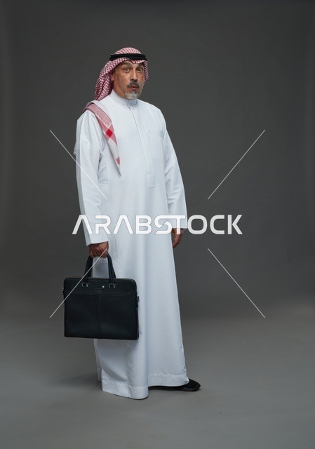 رجل اعمال عربي سعودي خليجي  يرتدي الزي الثوب الابيض والشماغ ويحمل حقيبة اللابتوب,  ايماءات واشارات مختلفه , كامل الجسم, خلفيه رماديه