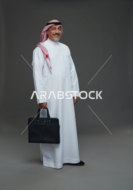 رجل اعمال عربي سعودي خليجي  يرتدي الزي الثوب الابيض والشماغ ويحمل حقيبة اللابتوب,  ايماءات واشارات مختلفه , كامل الجسم, خلفيه رماديه