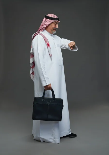 A Saudi Arabian Gulf businessman wearing a white thobe and a shemagh, carrying a laptop bag, with various gestures and signals, full body, gray background.